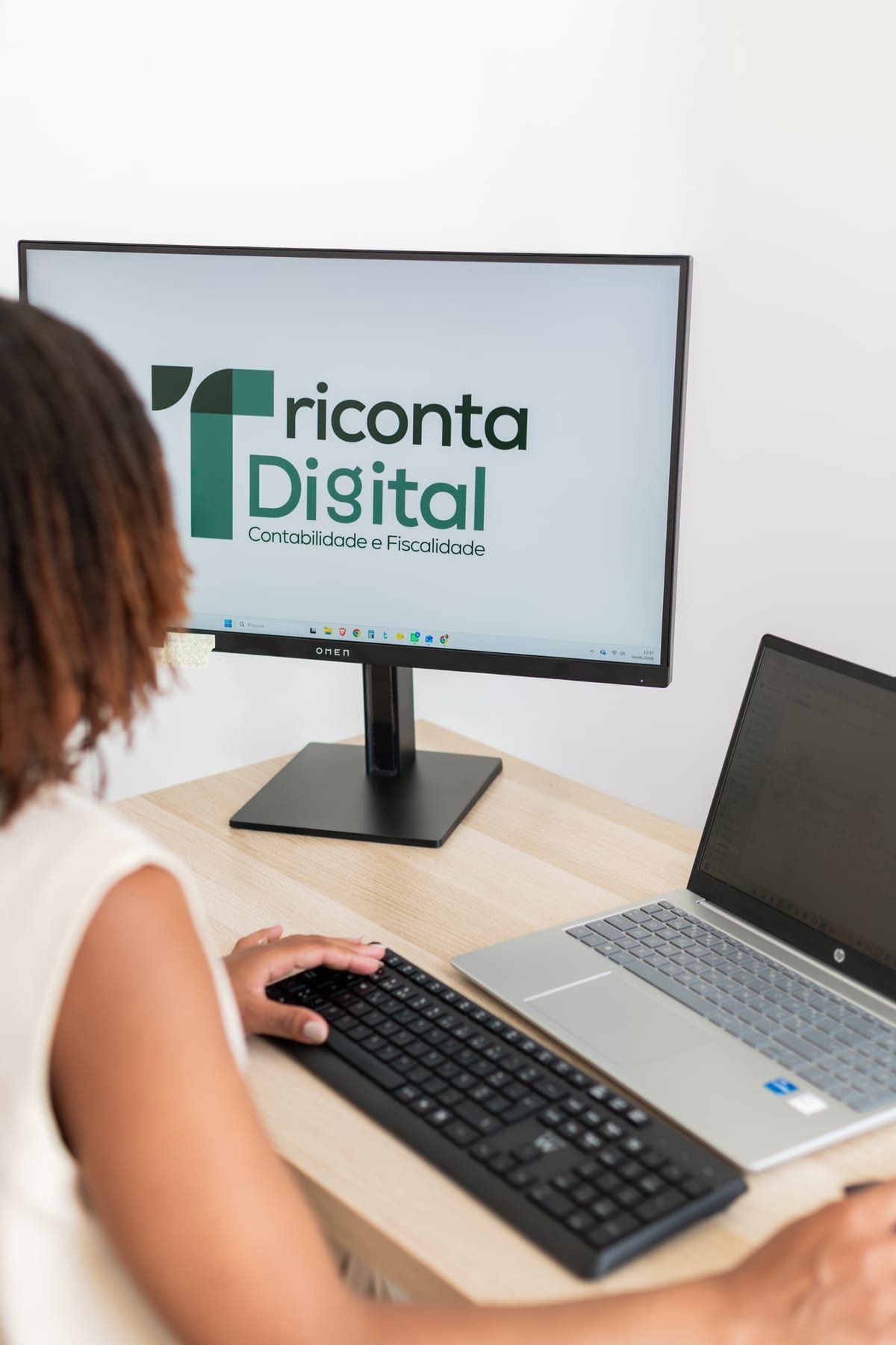 Escritório da Triconta Digital, com o logótipo da marca no ecrã
